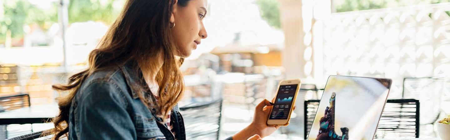 Kryptowährung: Frau handelt am Handy mit Kryptowährung