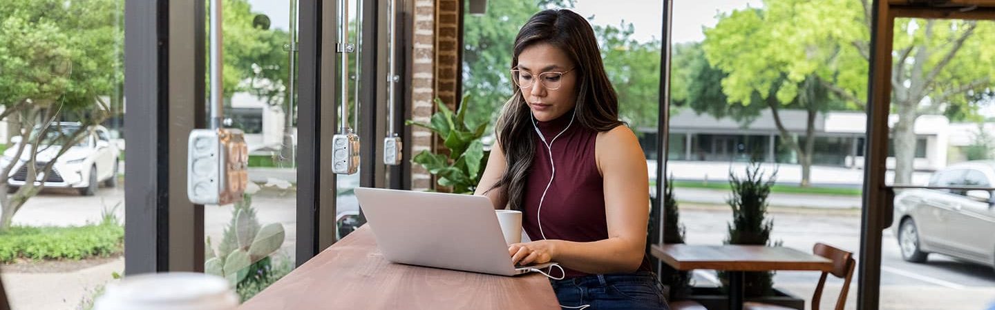 Richtig bewerben: Junge Frau verfasst Bewerbung am Laptop